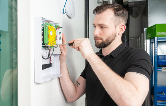 Technician installing a commercial access control panel for a business